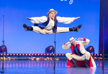 Artysta Baletu w kostiumie krzemienieckim uchwycony w podskoku na scenie