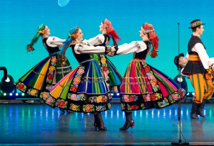 Artyści Mazowsza w kostiumach łowickich tańczą na scenie