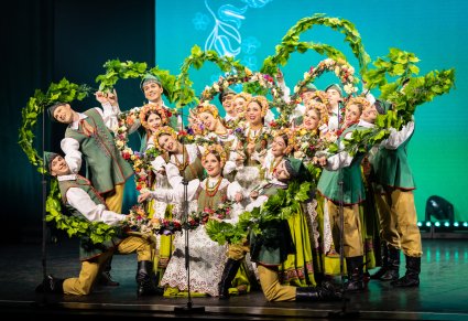Artyści w kostiumach lubuskich w układzie tworzącym kwiat na scenie