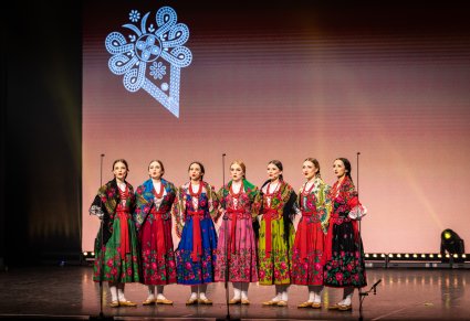 Artystki chóru w kostiumach góralskich śpiewają na scenie