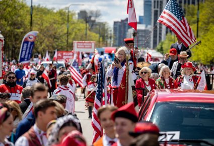 Uczestnicy Parady Konstytucji 3 Maja w Chicago ubrani w barwy biało-czerwone. Pojawiają się flagi Stanów Zjednoczonych i Polski