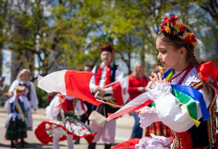 Zbliżenie na dziewczynkę w kostiumie krakowskim, trzymającą w ręku Polską Flagę na Paradzie Konstytucji 3 Maja w Chicago
