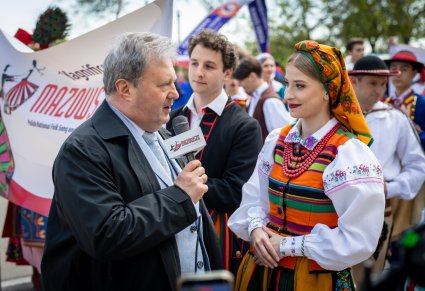 Dyrektor zespołu zwrócony w stronę Artystki w kostiumie łowickim