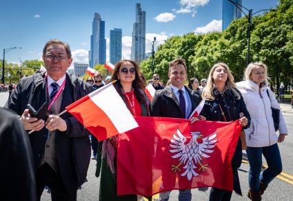 Sekretarz Marszałka Województwa Mazowieckiego trzymający flagę Województwa Mazowieckiego, obok niego pracownicy Administracyjni zespołu "Mazowsze" na Paradzie Konstytucji 3 Maja w Chicago