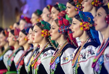 Zbliżenie na Artystki Chóru w kostiumach łowickich w trakcie śpiewu
