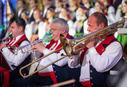Zbliżenie na trzech Muxzyków grających na instrumentach dętych. Artyści maja na sobie kostiumy wilanowskie