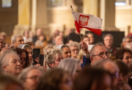 Publiczność koncertu w Bazylice Św. Jacka w Chicago, Jedna z osób trzyma w górze flagę Polski