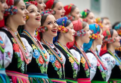 Zbliżenie na Artystki Chóru w kostiumach łowickich podczas śpiewu