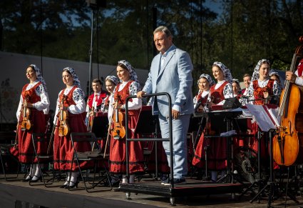 Dyrektor zespołu razem z częścią orkiestry na początku koncertu