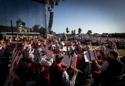 Na pierwszym planie orkiestra w kostiumach wilanowskich razem z Dyrektorem zespołu w roli dyrygenta - widok ze sceny