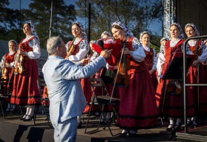 Dyrektor zespołu przekazuje kwiaty koncertmistrzyni