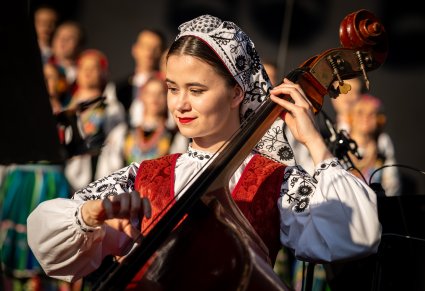 Zbliżenie na członka orkiestry, grającego na instrumencie smyczkowym