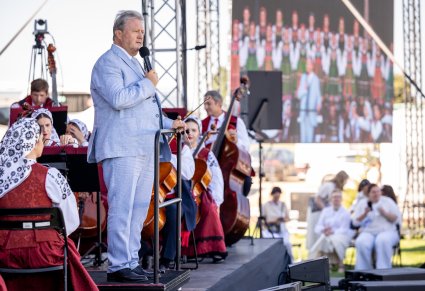 Dyrektor zespołu przemawiający podczas koncertu