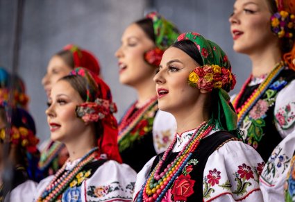 Zbliżenie na chórzystki w kostiumach łowickich, na scenie podczas koncertu
