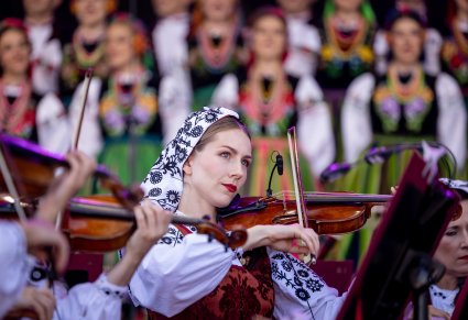 Zbliżenie na skrzypaczkę w kostiumie wilanowskim, w tle chór
