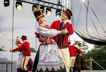 Artyści baletu w kostiumach kurpiowskich podczas tańca