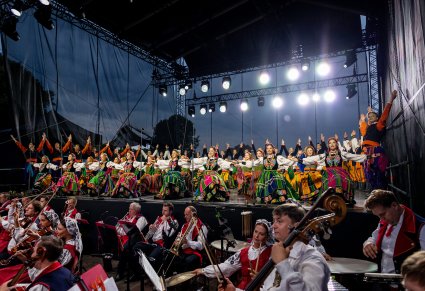 Zbliżenie na balet w kostiumach łowickich, niżej orkiestra w kosiumach wilanowskich