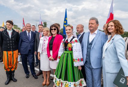 Dyrektor zespołu "Mazowsze" wraz z parą Artystów w kostiumach kocierzewskich w trakcie oficjalnego otwarcia mostu na Narwi w Gminie Rzewnie