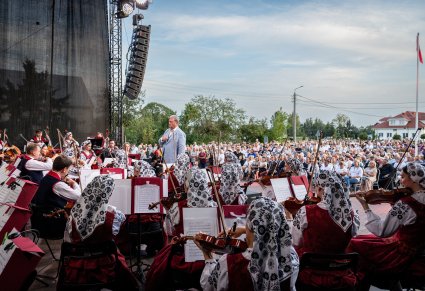 Widok na Orkiestrę w kostiumach wilanowskich wraz z Dyrygentem, w tle widoczna publiczność