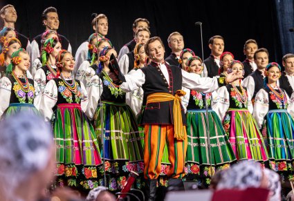 Na pierwszym planie Solista wykonujący utwór "Furman" w tle chór w kostiumach łowickich