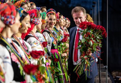 Wójt Gminy Rzewnie w trakcie rozdawania róż Artystkom w kostiumach łowickich