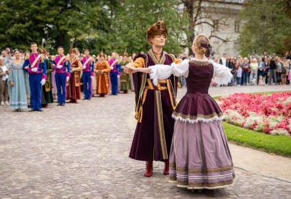 Na pierwszym planie para Artystów w kontuszach przedstawiająca podstawowa kroki Poloneza