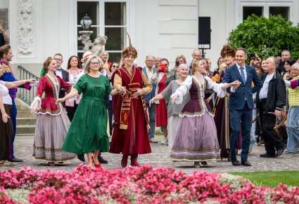 Grupa Artystów "Mazowsza" wraz z Publicznością przed Pałacem Myślewickim podczas Poloneza