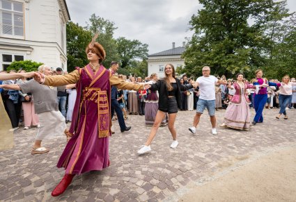 Zbliżenie na Artystów "Mazowsza" podczas wspólnego tańca Poloneza wraz z Publicznością przed Pałacem Myślewickim w Łazienkach Królewskich