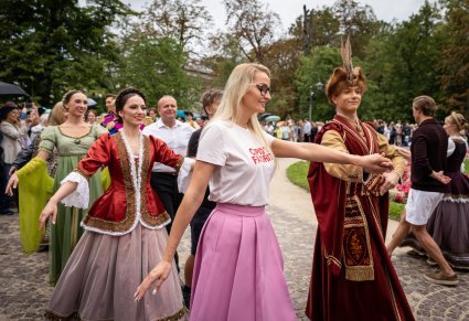 Zbliżenie na Pary Artystów "Mazowsza" i Publiczności podczas wspólnego Poloneza przed Pałacem Myślewickim w Łazienkach Królewskich
