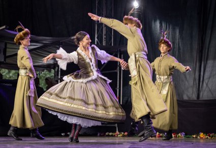 Zbliżenie na Artystów Baletu w kontuszach w trakcie wykonywania choreografii tanecznej