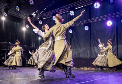 Zbliżenie na pary Artystów w kontuszach w trakcie wykonywania choreografii tanecznej