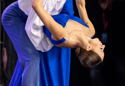 Zbliżenie na parę Artystów w kostiumach współczesnych w trakcie wykonywania choreografii tanecznej