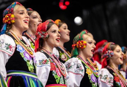 Zbliżenie na Artystki Chóru w kostiumach łowickich podczas śpiewu