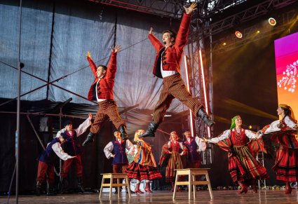 Tancerze baletu, w kostiumach sieradzkich, podczas tańca na scenie