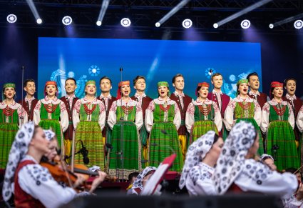 Część chóru w kostiumach kurpiowskich, poniżej część orkiestry w kostiumach wilanowskich