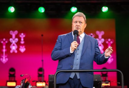 Dyrektor zespołu przemawiający podczas koncertu