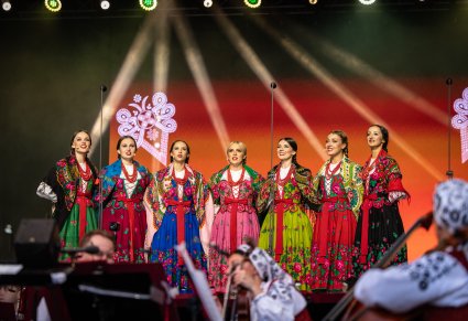 Chórzystki w kostiumach podhalańskich, na scenie podczas koncertu