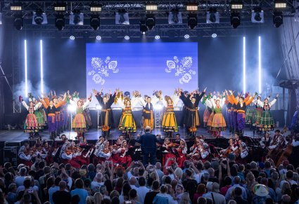 Chór w kostiumach łowickich i sannickich, razem z orkiestrą w kostiumach wilanowskich oraz Dyrektorem zespołu, podczas finału koncertu