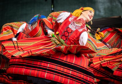 Zbliżenia na Artystki w kostiumach sieradzkich w trakcie wykonywania choreografii tanecznej