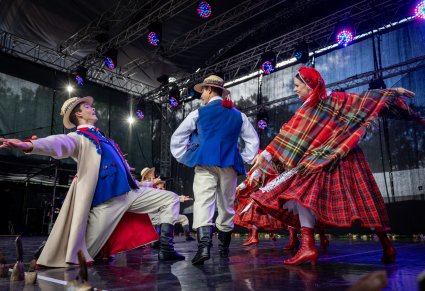 Pary Artystów w kostiumach łańcuckich w trakcie wykonywania choreografii tanecznej na scenie