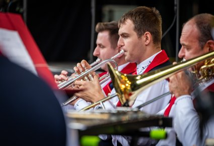 Zbliżenie na Artystów Orkiestry w kostiumach wilanowskich grających na instrumentach dętych