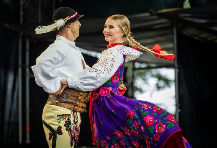 Para Artystów w kostiumach podhalańskich w trakcie wykonywania choreografii tanecznej