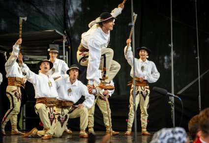 Grupa Artystów w kostiumach podhalańskich podczas wykonywania imponującej choreografii tanecznej w stylu góralskim