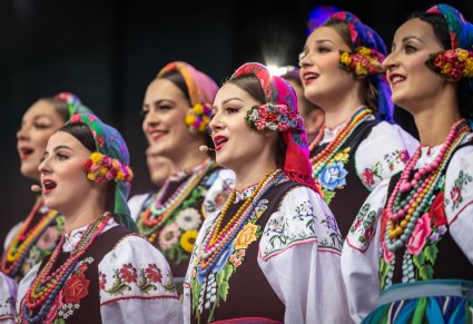 Zbliżenie na Artystki Chóru w kostiumach łowickich podczas śpiewu
