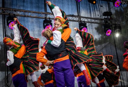 Pary Artystów w kostiumach sannickich w trakcie wykonywania choreografii tanecznej