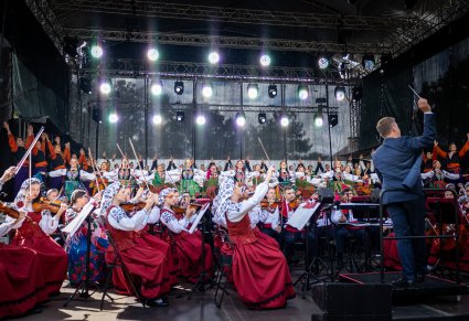 Na scenie Artyści Orkiestry w kostiumach wilanowskich wraz z Dyrygentem, Artyści Chóru i Baletu w finałowej pozie.