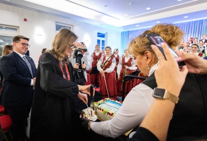 Kierownik Centrum Folkloru Polskiego "Karolin" krojąca urodzinowy tort