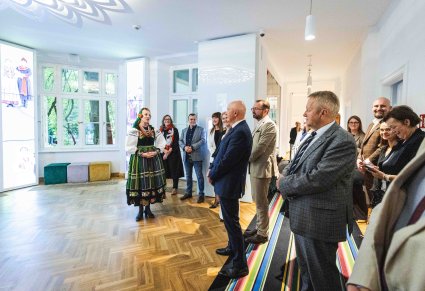 Przewodniczka w kostiumie łowickim wraz z Uczestnikami Konwentu Przewodniczących Sejmików Województw RP podczas zwiedzania Centrum Folkloru Polskiego "Karolin"