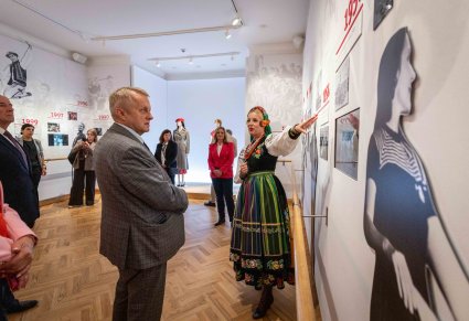 Uczestnicy Konwentu podczas zwiedzania wystawy stałej w Centrum Folkloru Polskiego "Karolin" wraz z przewodniczką. Przewodniczka ma na sobie kostium łowicki