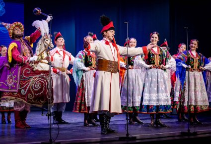 Na scenie grupa Artystów w kostiumach krakowskich oraz postać Lajkonika